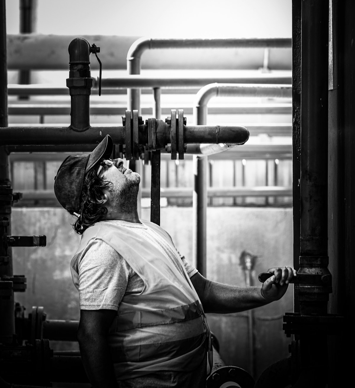 Technicien inspectant tuyauteries et vannes industrielles